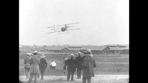 CIRCA 1908 - Orville Wright flies with a passenger at Fort Meyer, Virginia, where he is watched by civilians and servicemen.
