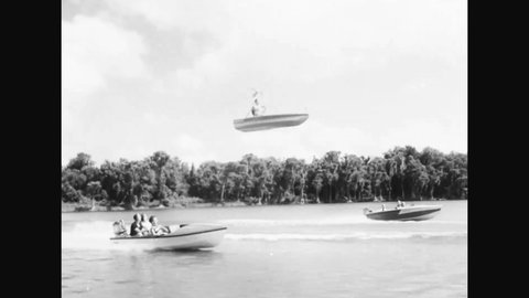 CIRCA 1955 - While his friends ride in typical motorboats, a man flies above them in the Bensen B-8 Gyro-glider.