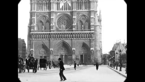 CIRCA 1880s - People drive carriages and walk past Notre Dame in Paris.