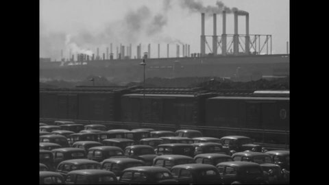 CIRCA 1938 - Smokestacks and cars in the employee parking lot of an industrial factory in Cleveland, Ohio.