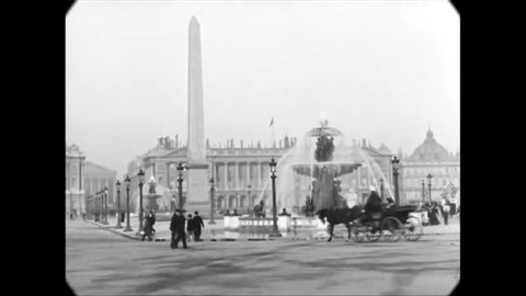 CIRCA 1880s - People walk and drive carriages past an obelisk and fountain in Paris.
