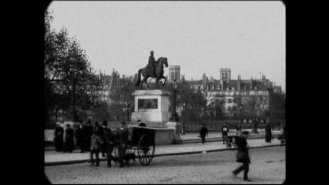 CIRCA 1896 - Horse-drawn carriages and foot traffic pass by a statue in Le Pont-Neuf, Paris, France.