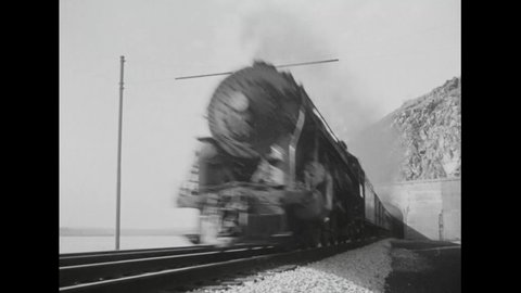 CIRCA 1942 - A fast steam passenger train passes through a mountain tunnel.