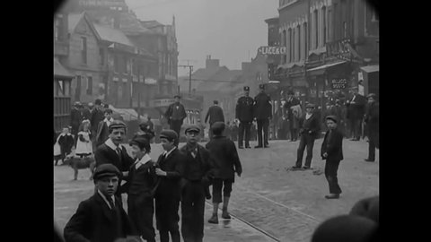 CIRCA 1902 - People get off and on a trolley in an English city.
