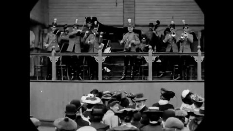 CIRCA 1904 - A band and dancers perform for a lively audience at Blackpool Victoria Pier in Lancashire.