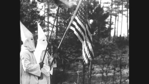 CIRCA 1920s - At a racist KKK rally in Stone Mountain, Georgia, the American flag is honored and children are present.