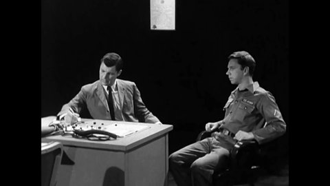 CIRCA 1960s - A Chief Warrant Officer explains the process as a Polygraph Examiner establishes a rapport with a suspect.