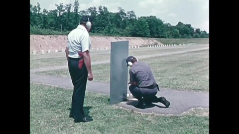 CIRCA 1974 - An instructor teaches basic shooting techniques, including firing a revolver from a kneeling weak hand position.