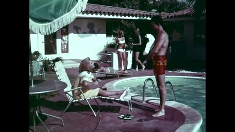 CIRCA 1966 - A military pilot discusses supersonic jet school and apartment hunting with his wife as he emerges from a swimming pool.
