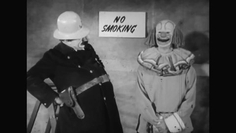 CIRCA 1951 - Bozo the Clown taunts a cop clown with a trick cigarette, which he can partially swallow, in a No Smoking zone.