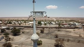 4K aerial drone video of Usakos, small town in Erongo Mountains near B1 highway to west coast of Namibia and its old historical railway water towers on hot sunny day, Erongo Region, central Namibia