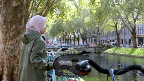 Muslim Woman Beside Old Bicycle Enjoying View of Canal Inside Düsseldorf City - Cam B