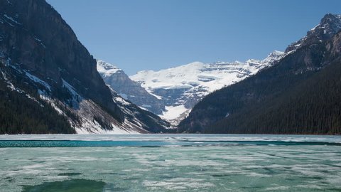 4K Time lapse zoom out of Lake Louise in spring with broken ice on the surface. Lake Louise is one the most visited lakes at Banff National Park, Alberta, Canada.