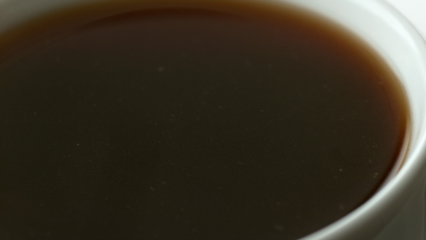 Cream pouring into cup of coffee in slow motion.  Shot with Phantom Flex 4K camera.