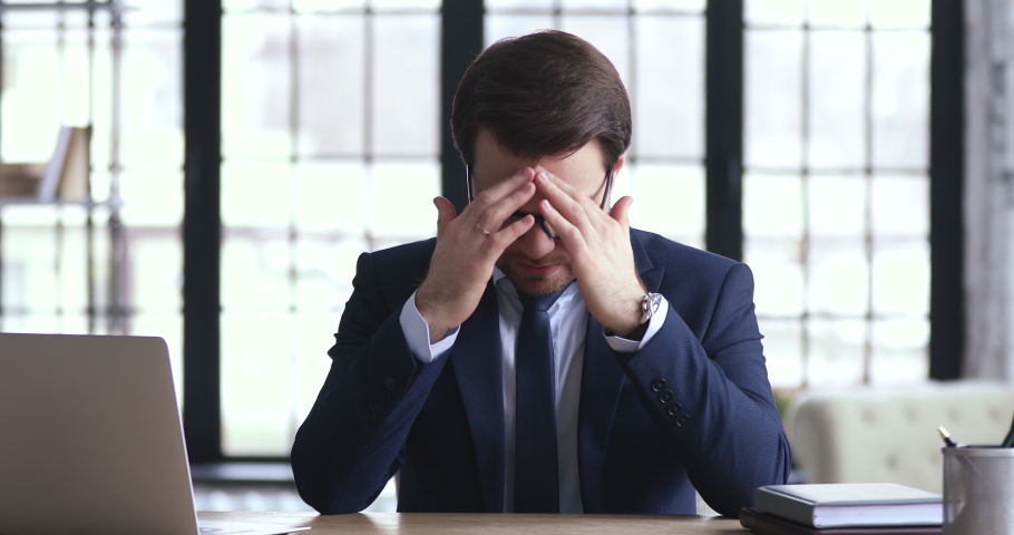 Depressed businessman ceo feels desperate loser frustrated by business failure sitting at office desk. Stressed insolvent executive in nervous tension worries about company bankruptcy problem concept. Royalty-Free Stock Footage #1048283758