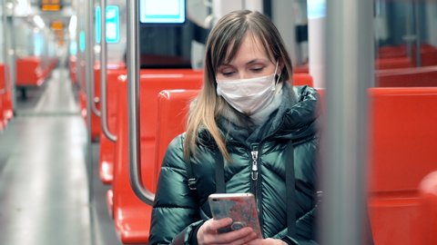 Young woman in protective medical face mask in a subway car, pandemic coronavirus concept