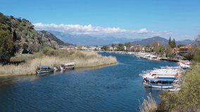Dalyan canal view and settlement, excursion tour on Dalyan river valley. Dalyan is popular tourist destination in Turkey. 4K Video Aerial view from drone.