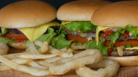 French fries, fried onion rings and hamburgers and cheeseburgers hamburgers or burgers with lettuce, meat patties and mustard ketchup sauce. Street fast food.