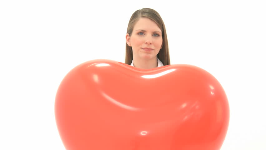 Woman lets heart balloon fly and crosses her arms