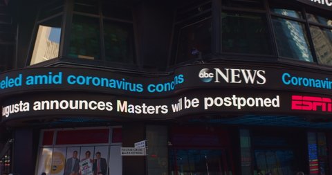 New York, New York / United States - March 13 2020: ABC News ticker displays latest headlines related to the Coronavirus, COVID-19. Effect on democratic primary. Postponement of Masters Golf Event.