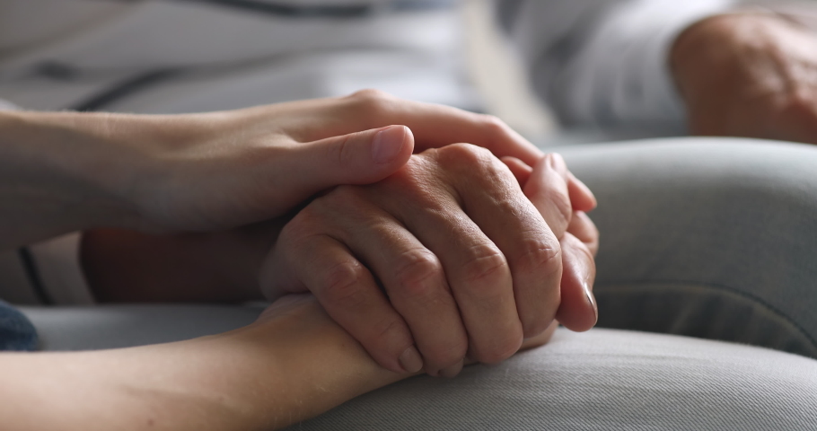 Close up young woman stroking hand of middle aged mother, enjoying sweet tender moment. Millennial caregiver or grown up daughter showing support respect to elderly mom, helping in health care. Royalty-Free Stock Footage #1048334791