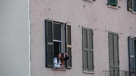 Milan, Italy - 14 March 2020:  People dance at the sound of music on their balconies during a flashmob launched to show unity against coronavirus covid-19 outbreak. Lockdown, curfew