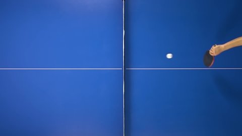 Ping pong concept. Two people playing on a blue table. Close-up top view. Slow motion