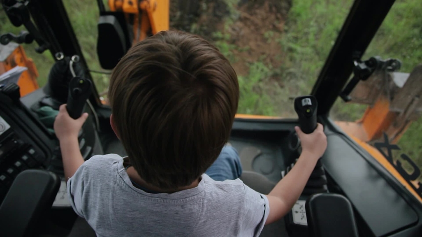 The child sits in the cab of the excavator and controls the bucket. Modern technology.