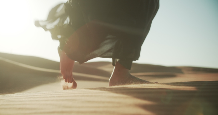 Close-up of girl in traditional Abaya dress walking barefoot along the dunes in the desert of Dubai. 4K Slow Motion | Shutterstock HD Video #1048362721
