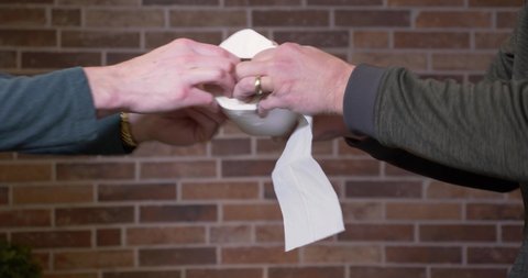 Two men fight over the last roll of toilet paper.  	Panic buying concept.