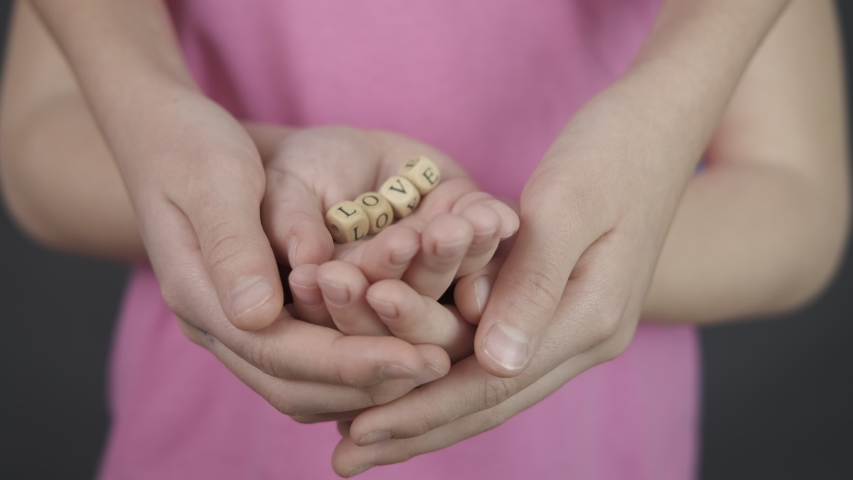 Hands of a child and mom. Hands of mother and child with the word love.