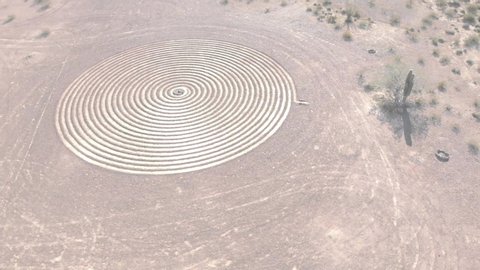 Aerial drone view of a man-made labyrinth circle pattern carved in the desert sand in Arizona. 