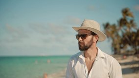 Handsome Man Walking On Tropical Beach. Guy Relaxing On Caribbean Beach. Beautiful Tanned Man In Hat Healthy Skin Sunbathing Enjoy Ocean Vacation. Happy Businessman Enjoying Tropical Sea Resort Hotel - Powered by Shutterstock - Get 15% off with code: PIKWIZARD15