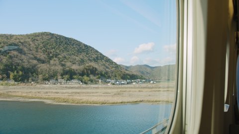 Passenger POV looking out from a high speed bullet train in the Japanese countryside from Hiroshima to Tokyo. Japan. Point of view.