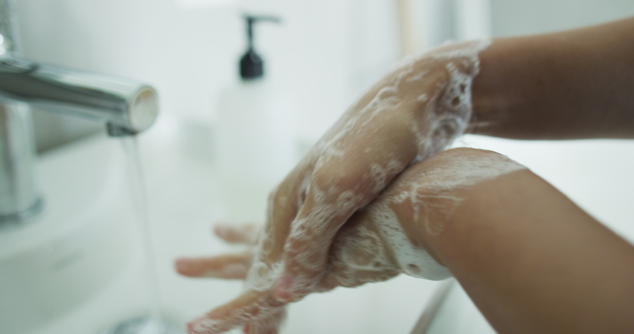Coronavirus pandemic prevention wash hands with soap warm water rubbing fingers washing frequently or using hand sanitizer gel. | Shutterstock HD Video #1048399522