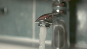 SLOW MOTION, CLOSE UP, DOF: Unrecognizable person closes the faucet after washing their hands. Glassy water stops flowing from the metal bathroom tap. Crystal clear tap water streaming into the sink. - Powered by Shutterstock - Get 15% off with code: PIKWIZARD15