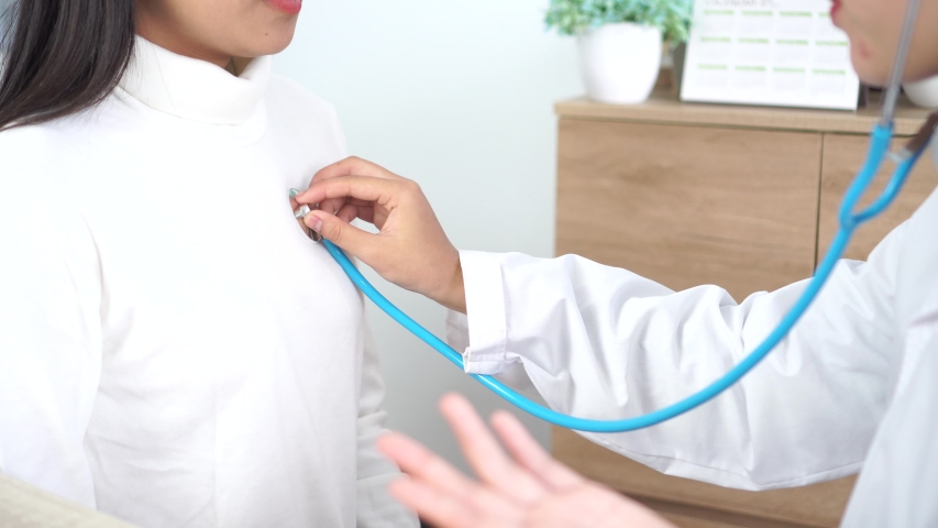 Doctor Female checking heart patient's vitals by stethoscope, Asian female physician listening nurse check body of beauty young girl patient in hospital for examining breath,Healthcare medical concept | Shutterstock HD Video #1048405354