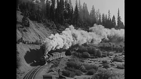 CIRCA 1930s - Steam engine passenger trains move through a forested landscape.