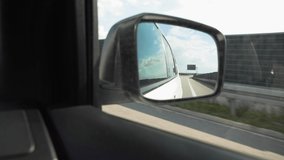 view of highway reflection in car mirror road trip concept