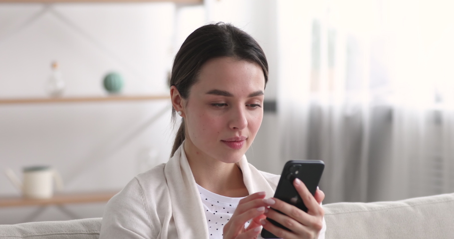 Happy young woman winner using smartphone looking excited about mobile win. Cheerful amazed female user holding cell phone celebrating bid win, reading great news, getting promotion message concept. Royalty-Free Stock Footage #1048429228