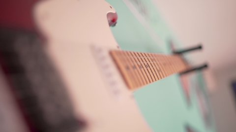 A vintage retro electric guitar from the fifties hanging on the wall in an american fifties bar filmed in close up on the snares.