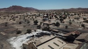 4K aerial drone video of Usakos, a small town in Erongo Mountains near B1 highway to west coast of Namibia and its old historical railway sheds on hot sunny day in Erongo Region, central Namibia