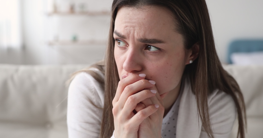Worried young woman feeling hurt, concerned about unwanted pregnancy, work or relationship psychological problem concept, close up view. Anxious nervous sad lady in tension thinking of mental stress. | Shutterstock HD Video #1048445893
