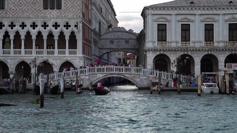VENICE, ITALY - SEP 4, 2019: Traditional gondola under Bridge of Sighs, Venice canal. Famous landmark in Italy. Summer tourism. Romantic honeymoon cruise ship destination in Europe. Slow motion drone