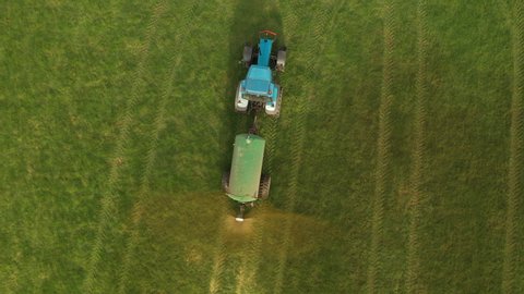 Tractor Muck Spreading Manure in a field and turning - Agriculture - Aerial Drone shot, looking down. Stock Video Clip Footage