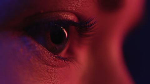 Pretty Eyes of Woman in Colourful Neon. Girl Looking Around at Studio. Abstract Shot of Female Face and Skin with Multi-Colour Flickering of Modern Street Signs. Concept of Young Lady in Red Lighting