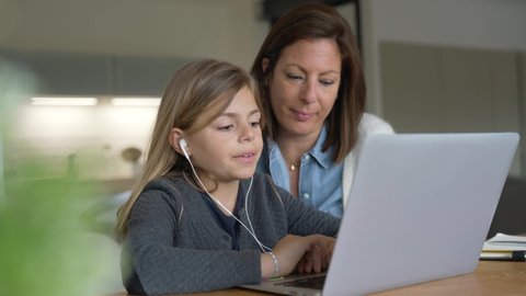 Mother and kid at home doing homework online