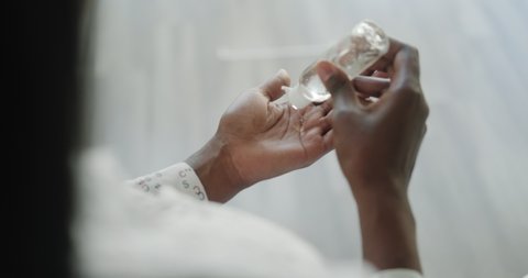 Sick black woman using liquid hand sanitizer during quarantine. Ill african american people using alcohol gel to clean hands and skin against virus, germs, bacteria for health care