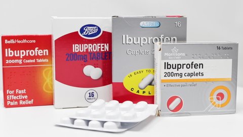 London / UK - March 17th 2020 - Ibuprofen anti-inflammatory medication boxes and packs of tablets slowly rotating on a white background. 