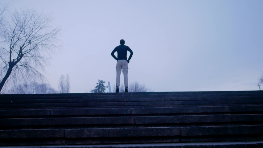 Sportsman jumping at the city stairs of morning city